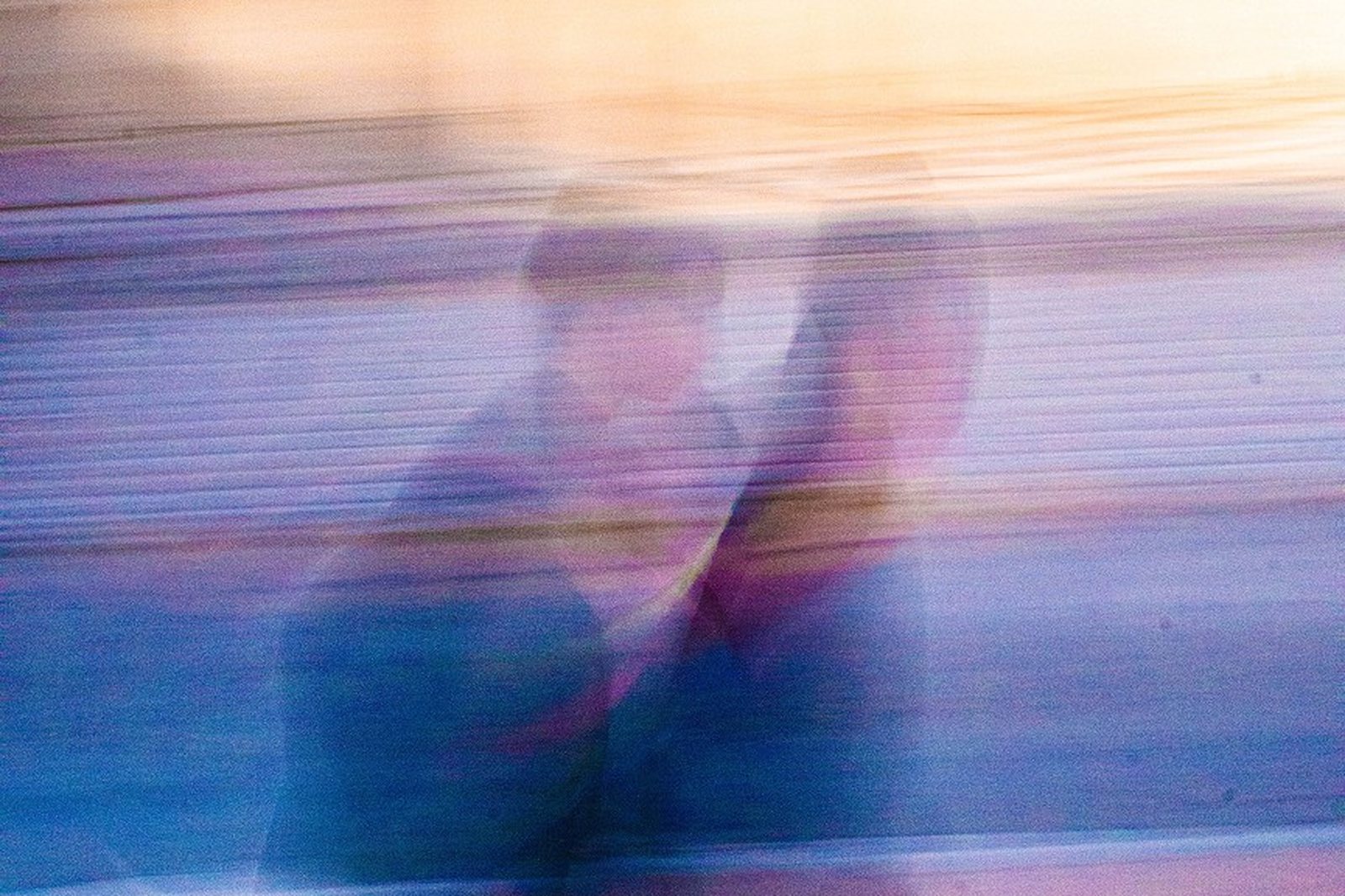 Two figures mid-exchange, dissolved into overlapping traces by a long exposure